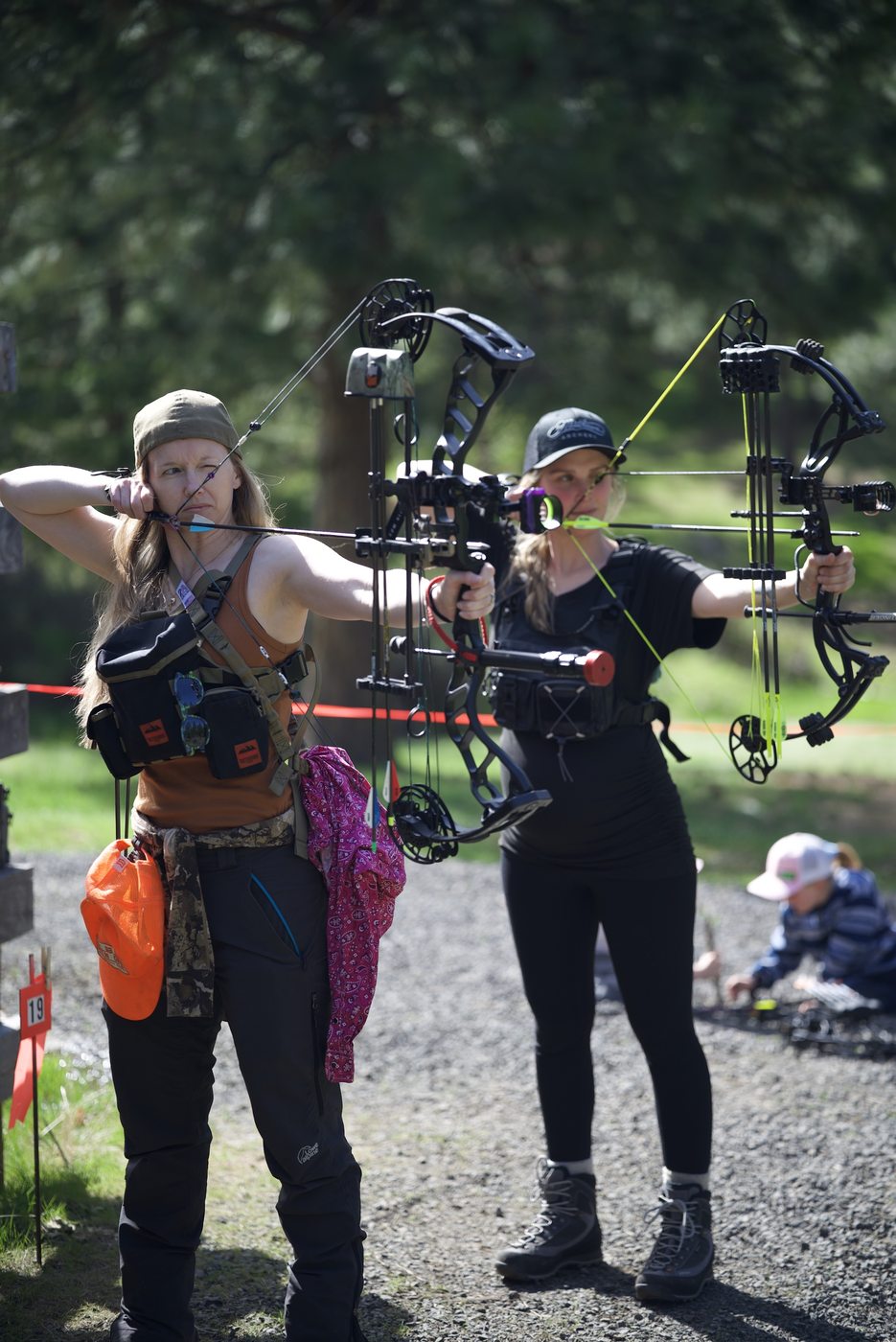 Two archers practicing together on an outdoor range